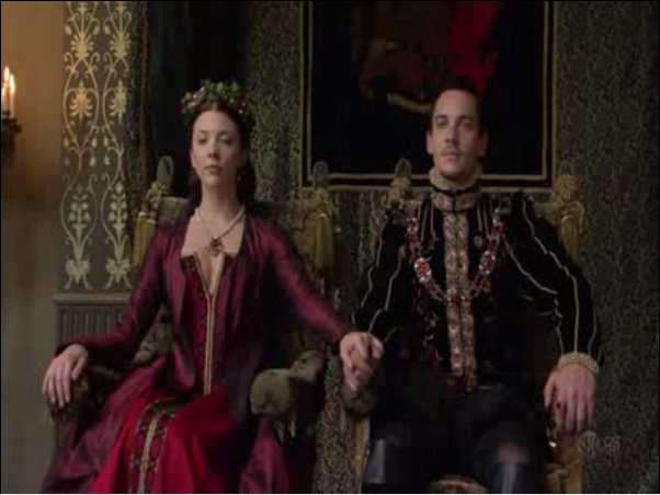 Anne in a beatiful red/crimson gown on her throne next to Henry as they exchange christmas gifts